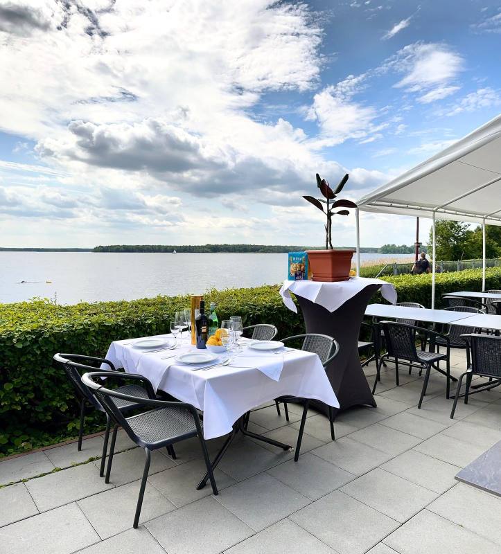 Table with white cloth on the lakeside terrace