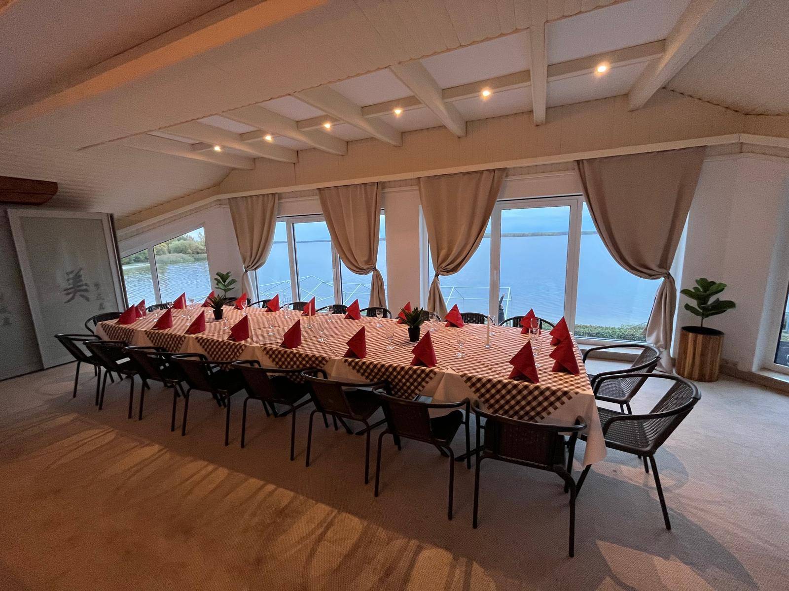 Long banquet table with checked tablecloths and red napkins